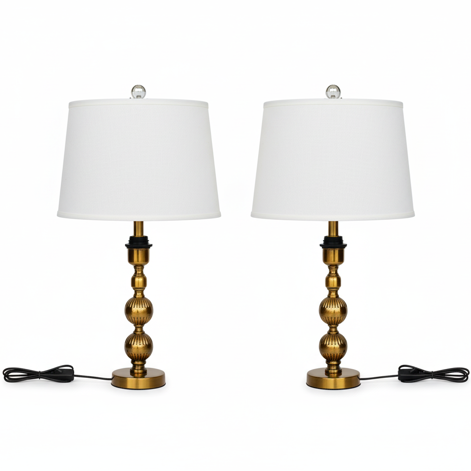 Two table lamps with brass bases and white shades on a white background