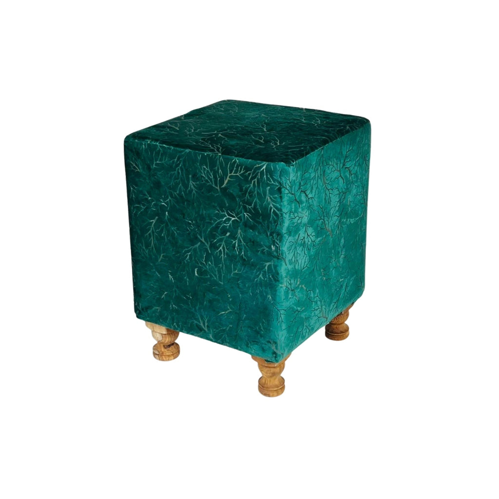 Green cube-shaped ottoman with wooden legs on a white background