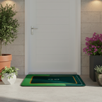 Green doormat with 'HOME' text on a concrete floor surrounded by potted plants.