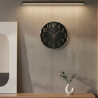 Modern wall clock on a textured wall with a wooden console table and decorative items.