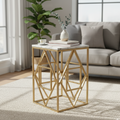 Gold geometric side table with a marble top in a living room setting.