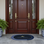Wooden front door with gold handles, two potted ferns, and a doormat on a stone patio.