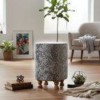Decorative cylindrical stool with floral pattern on a wooden floor in a living room setting.