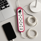 Pink and white power strip with multiple outlets on a desk next to a smartphone and laptop.
