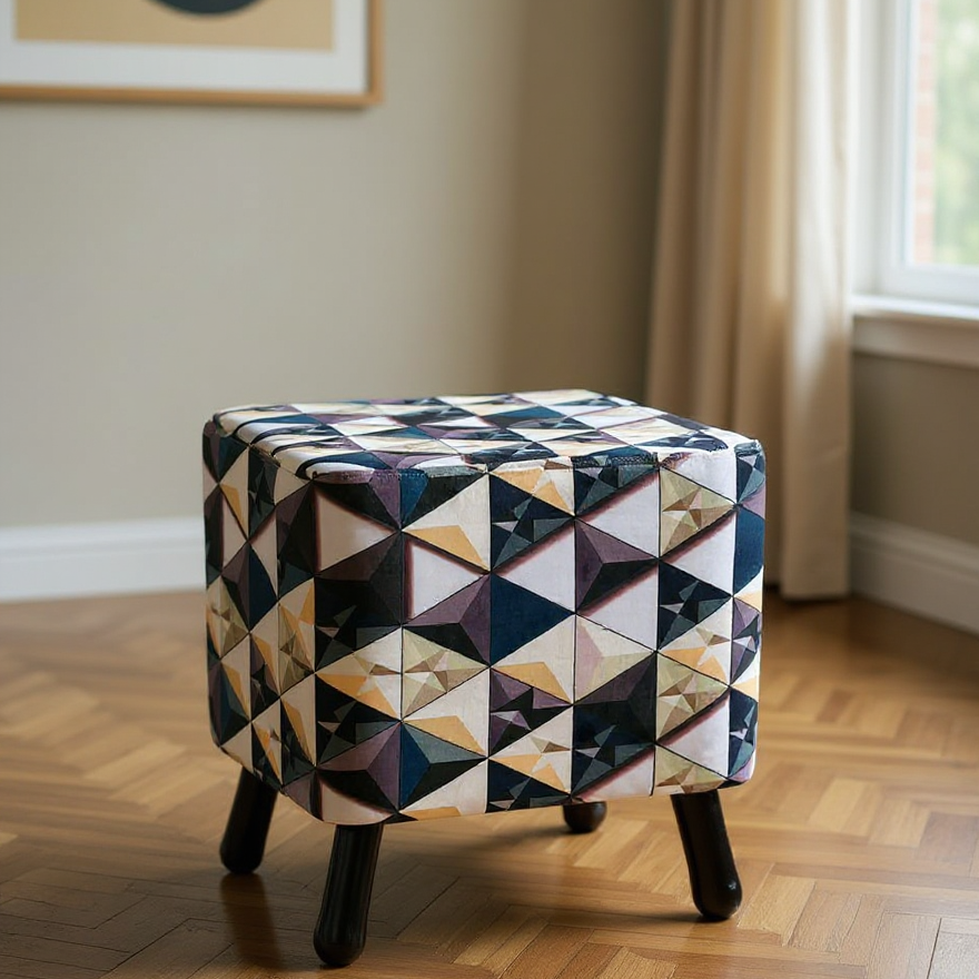 Patterned ottoman on a wooden floor with a window and artwork in the background